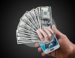 Hand holding dollar cash popping out from a phone screen