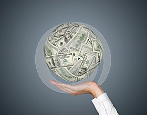 Hand holding dollars ball