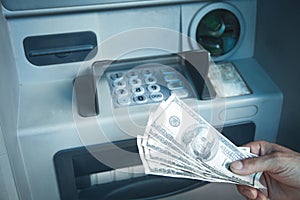 Hand holding dollars withdrawn from ATM