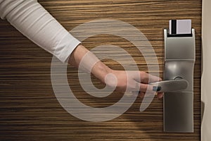 A hand holding door handle with modern keycard electronic lock