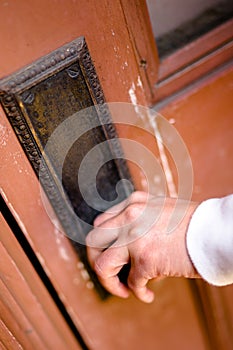 Hand Holding Door Knob to Open Wooden Door