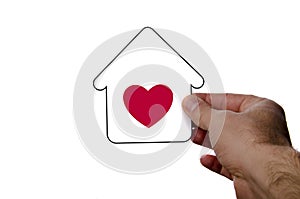 hand holding dream house icon with red heart over a whi