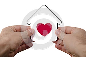 hand holding dream house icon with red heart over a whi