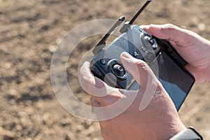 Hand holding drone remote controler to operate flying drone