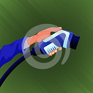 Hand holding electric car charger connector isolated on green background.