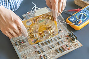 Hand holding an electric circuit board repair fix and assemble electronics concept f