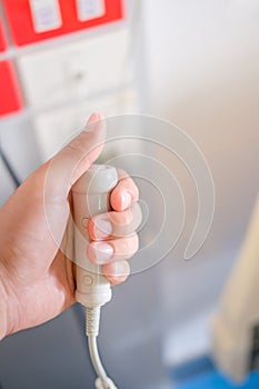 Hand holding emergency button in hospital room