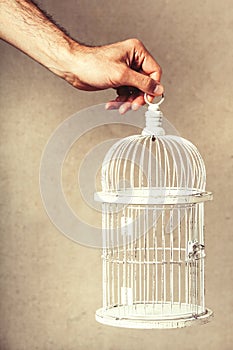 Hand holding an empty cage. Absence of ideas and dreams. Freedom and hope. photo