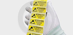 Hand holding ESD symbol label with antistatic gloves on gray background,Electrostatic Sensitive Devices ESD in electronic