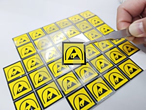 Hand holding ESD symbol label with tweezers,Electrostatic Sensitive Devices (ESD) in electronic industrial.