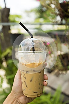 Hand holding espresso iced coffee.