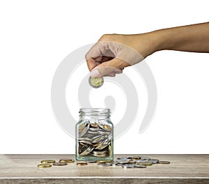 Hand holding European money coin to bottle and coins on wooden table