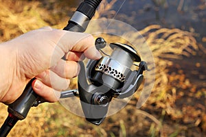 Hand Holding Fishing Pole And Fishing Reel