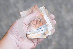 Hand holding fistful of euro banknotes