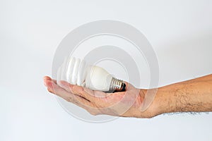 Hand holding fluorescent light bulb