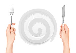 Hand holding fork and knife with plate