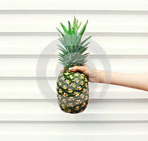 Hand holding fruit pineapple over white background