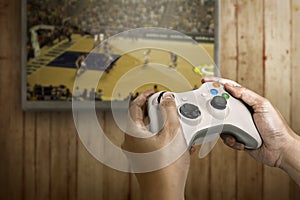 Hand holding game console controller playing game