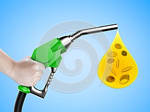 Hand holding gas pump nozzle with oil drop and gold coins