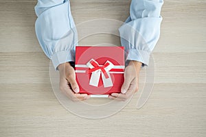 A hand holding a gift box Glad to be the giver of surprise with excitement, joy on the holidays, Christmas, birthdays, or