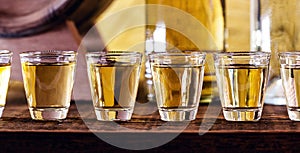 Hand holding glass of alcoholic drinks, cachaÃ§a, drips, rum and cognac. Selection of strong and hard alcoholic drinks, glasses.