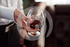 Hand holding a glass of cognac