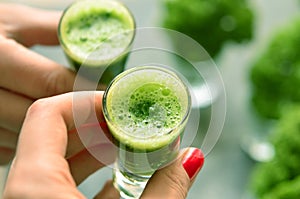 Hand holding a glass with kale coctail photo