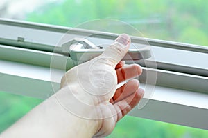 Hand holding glass window latch lever photo