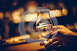 Hand holding a Glencairn single malt whisky glass photo