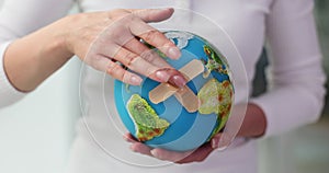 Hand holding globe and adhesive patch