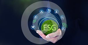 Hand holding globe with ESG icon green earth concept for environment Society and Governance sustainable environmental concept of
