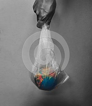 hand holding globe in plastic bag on black background concept earth day