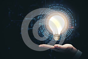 Hand holding glowing light bulb