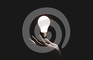 Hand holding glowing lightbulb for creative thinking innovation idea and problem solving concept