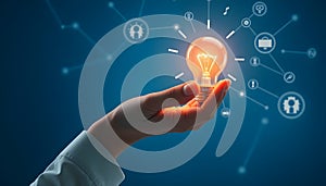 Hand holding a glowing lightbulb, representing idea generation and innovative thinking concept on