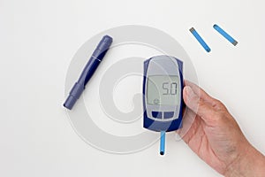 Hand holding glucometer with 5.0 result