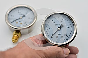 Hand holding a pressure gauge photo