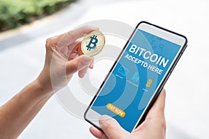 Hand holding gold bitcoin pay bill online store on mobile app.digital currency.banking financial technology.accepted bitcoin here.