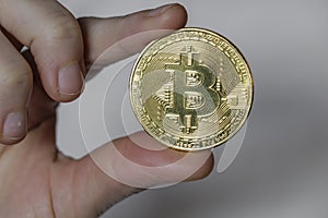 Hand Holding Gold Bitcoin Token