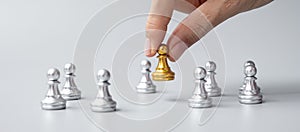 Hand holding golden chess pawn pieces or leader businessman with of silver men. victory, leadership, business success, team,