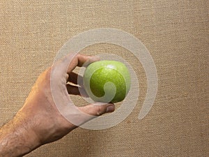 Hand holding Granny Smith apple