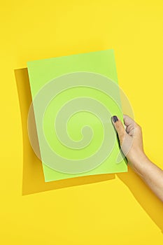 Hand holding green paper mockup