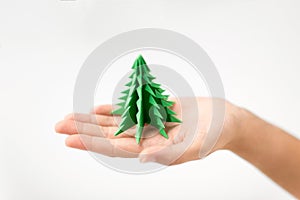 Hand holding green paper origami christmas tree