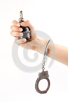 Hand holding a grenade in handcuffs