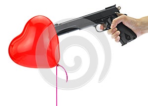 Hand holding at gunpoint a heart balloon photo