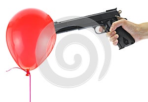 Hand holding at gunpoint a red balloon