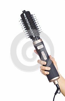 Hand holding hair curling iron round brush