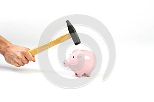 A hand holding a hammer which is raised above a standing pink piggy bank