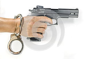 Hand holding a hand gun with handcuffs