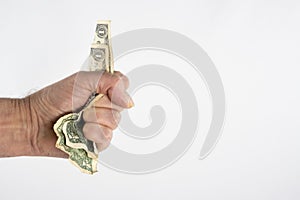 A hand holding a handful of us dollar bills on white background and copy space